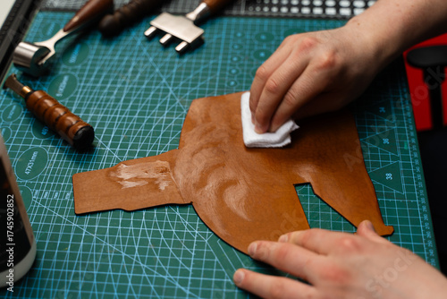 Slika na platnu Applying conditioner or dye to leather with a cloth