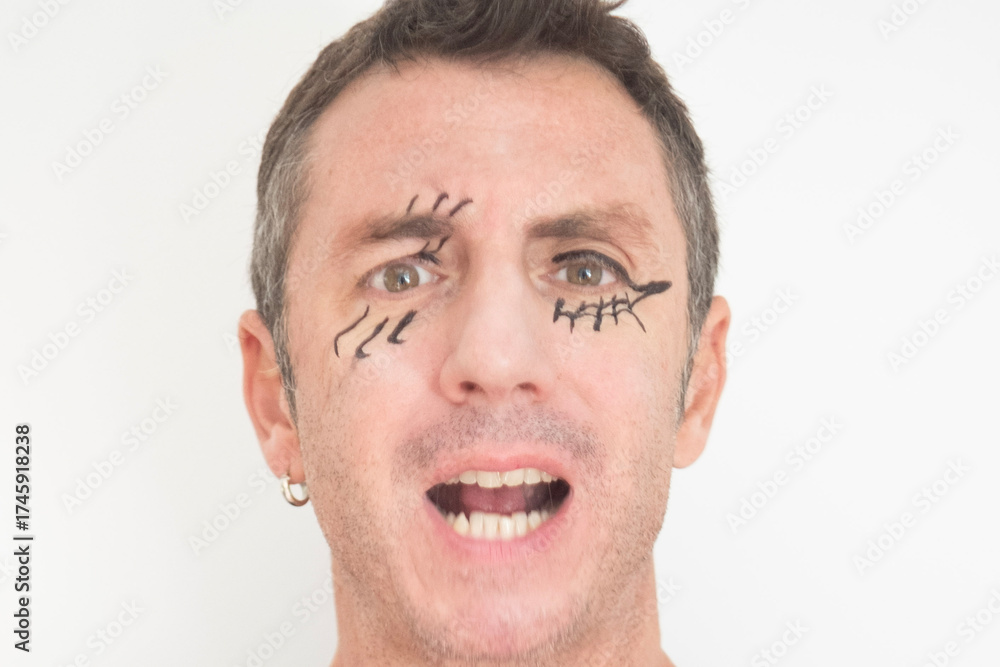 Fototapeta premium Close up of man with face made up for Halloween. The man is forty years old and of Caucasian origin