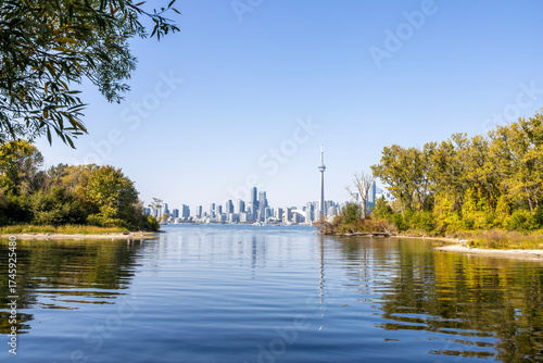 Photography Stunning view of the Toronto skyline from Sunfish Cut on Ward's Island, showcasing the iconic CN Tower and Lake Ontario's serene waters