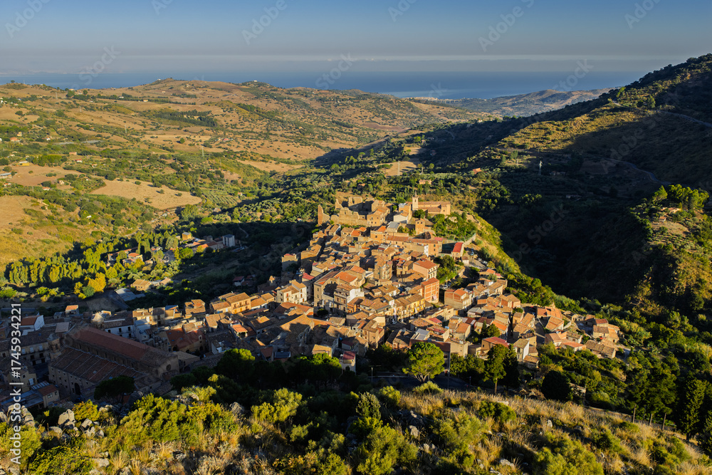 Obraz premium Aerial drone view of Collesano Sicilian mountain town at sunset with Basilica San Pietro church and historic stone streets in the Madonie Mountains, Sicily, Italy. Old mountain town in Sicily