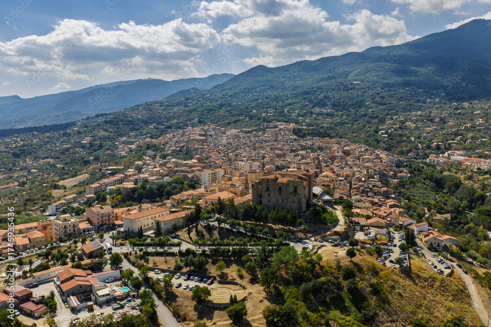 Obraz premium Aerial drone view of Castelbuono medieval town in the Madonie Mountains, Sicily, Italy, basking under the summer sun with historic streets, Ventimiglia Castle. Old mountain town in Sicily
