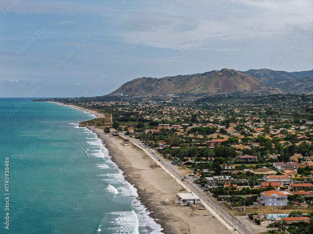 Fototapeta premium Aerial drone view of Campofelice di Roccella, a charming Sicilian seaside town in northern Sicily, Italy, showing traditional holiday homes, coastline, and panoramic Tyrrhenian Sea vistas