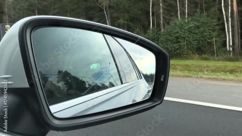 view of the road and the side rearview mirror of a car