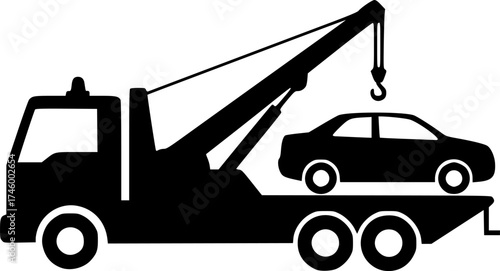 Silhouette of a tow truck lifting a broken down car with its crane
