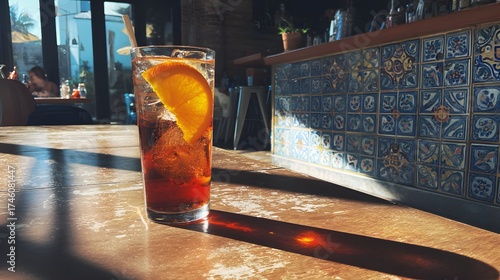 Refreshing Iced Tea with Orange Garnish on Sunlit Tiled Table