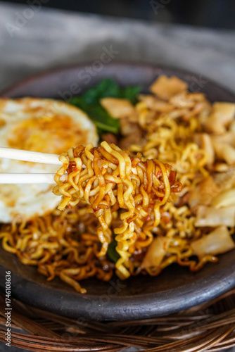 Grilled Chili Noodles, captured on October 8, 2025. Spicy stir-fried noodles charred over flames, topped with fresh herbs and chili, vibrant Indonesian street food scene