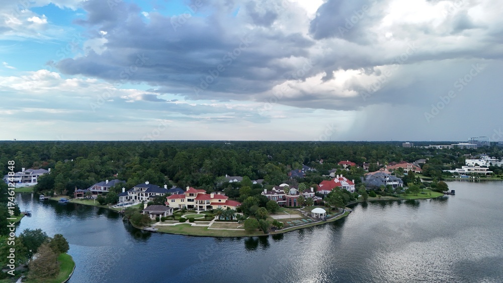 Obraz premium Aerial view of luxury houses in Houston, Woodlands by the lake with dramatic cloudy sky in Texas, United States on 10/08/2025