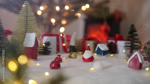 Santa claus doll with christmas decorations with blurred lights on christmas tree.