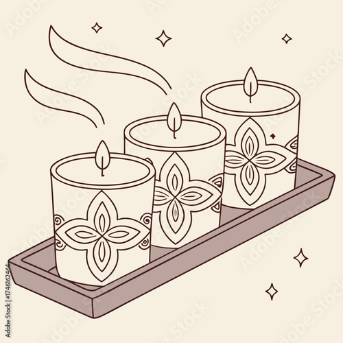 Three decorative scented candles with floral patterns and gentle smoke rising on a tray
