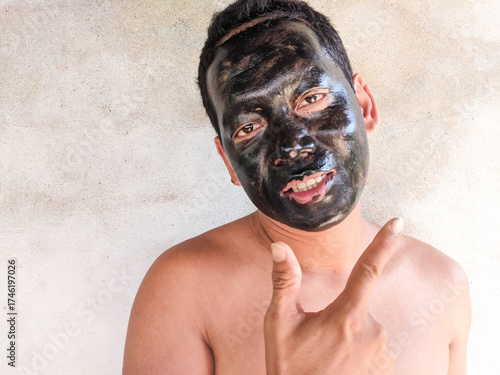 An Asian man using a facial treatment mask