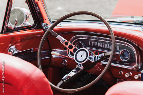 Close up shot of steering wheel on a red vintage car