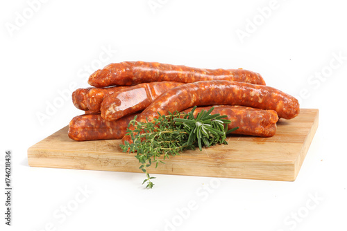 Raw merguez sausages on a wooden board, isolated on a white background