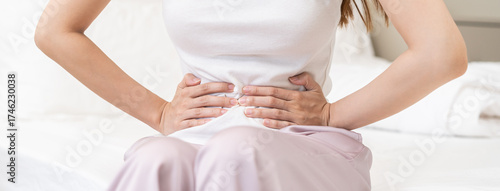 Obraz na płótnie Flatulence ulcer, asian young woman, girl hands in belly, stomach pain from food poisoning, abdominal pain and digestive problem, gastritis or diarrhoea
