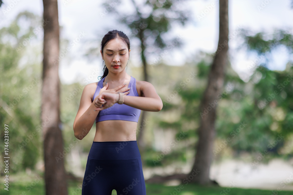 Fototapeta premium Woman checking heart rate on smartwatch after exercise