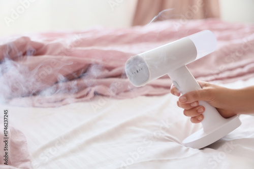 Young woman steaming bed sh...