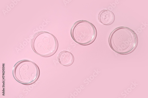 Petri dishes with transparent liquids on pink background