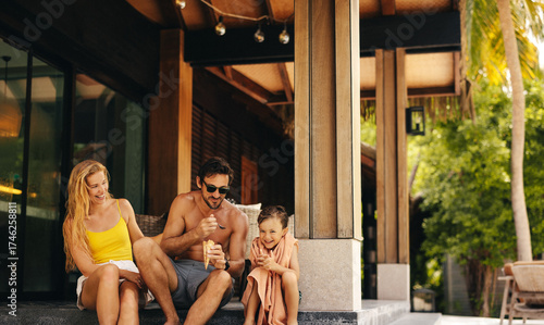 Happy family enjoying ice cream at a tropical island resort