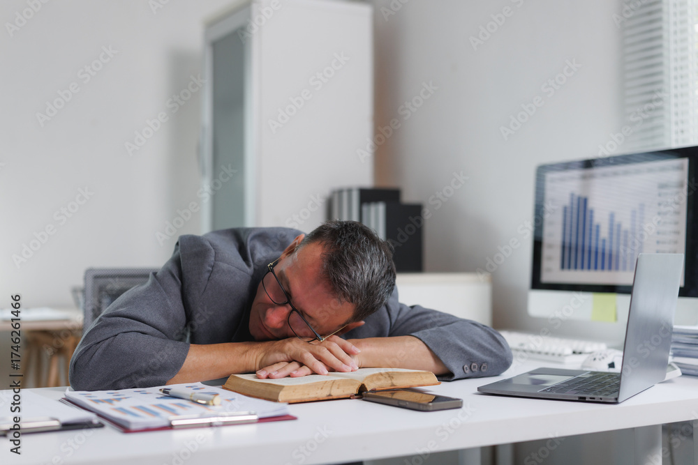 Obraz premium Businessman sleeping on office desk experiencing burnout