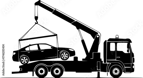 A black tow truck lifting a black car