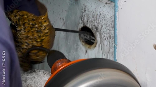 A plumber snaking the bathtub drain 