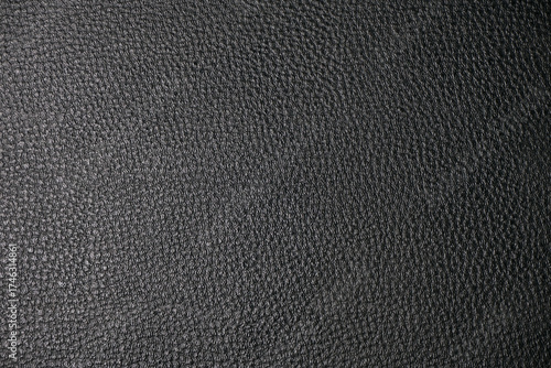 Macro photo of black pebbled leather with visible grain and diagonal seam, detailed texture ideal for design, crafts, upholstery or background use in creative projects.
