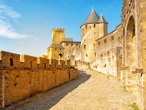 Medieval fortress walls and towers of Carcassonne at sunset, France. Old medieval walls of Carcassonne illuminated by purple sunset sky.