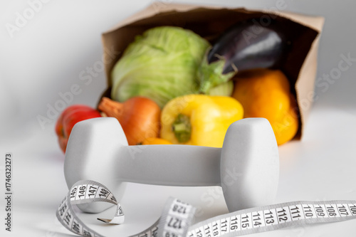 healthy eating, diet, and fitness concept - vegetables and dumbbells