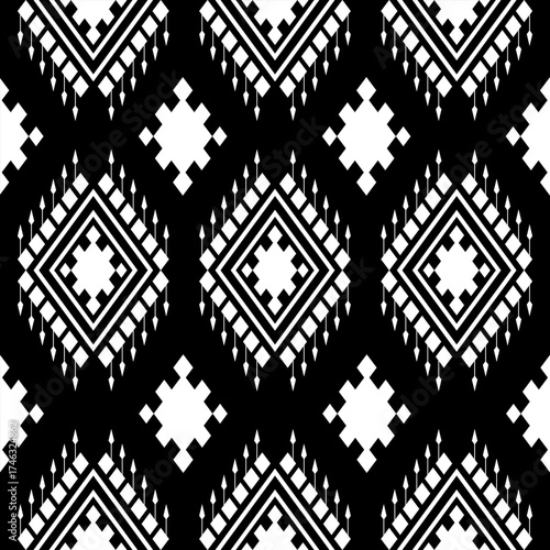 Black and white geometric tribal pattern featuring diamonds and hanging fringe elements repeating symmetrically ethnic seamless