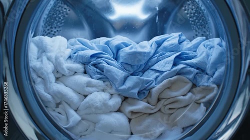 Washing machine drum filling with water and clothes during laundry cycle