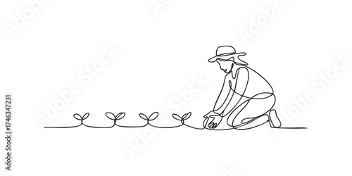 Gardener kneeling and planting seedlings