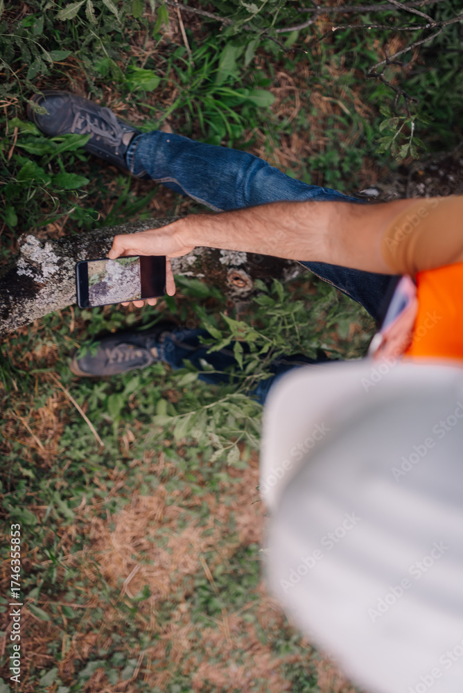 Naklejka premium Surveyor taking pictures of vegetation with smartphone