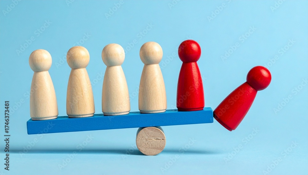 Obraz premium wooden figurines on seesaw showing imbalance with one red figure falling off