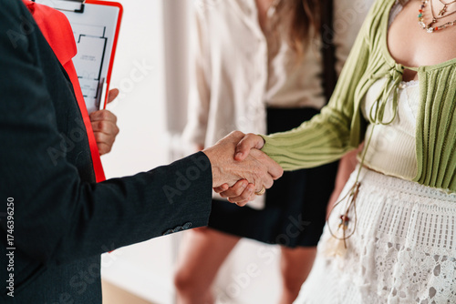Real estate agent shaking hands with client after apartment viewing