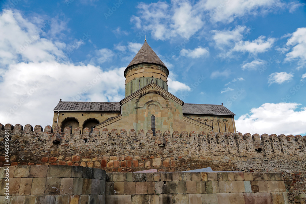 Fototapeta premium The outside view of Svetitskhoveli Cathedral which is an Orthodox Christian cathedral located in the historic town of Mtskheta, Georgia, The cathedral is surrounded by a stone wall