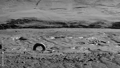 Tyre in muddy river bank