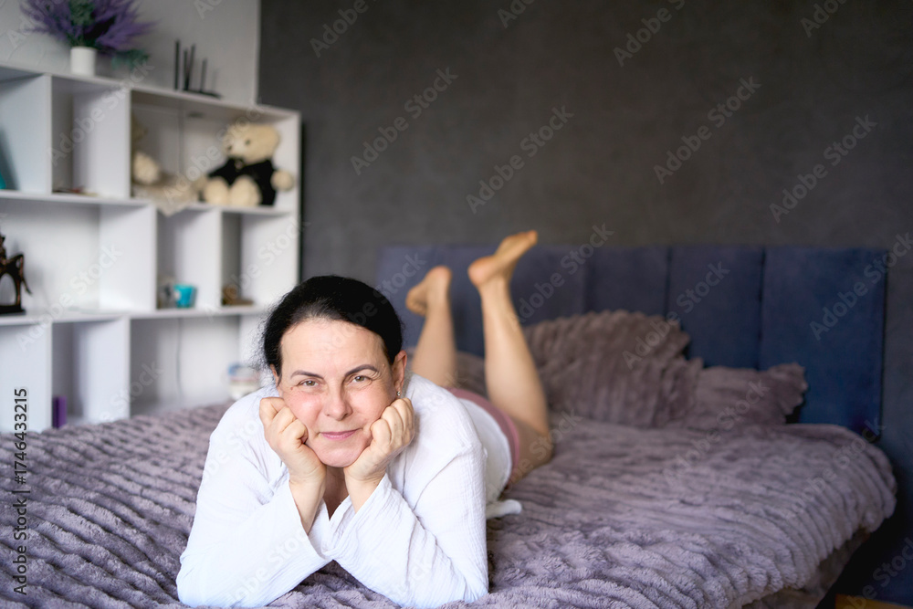 Obraz premium a senior woman in underwear stretching, resting, enjoying life on bed at home