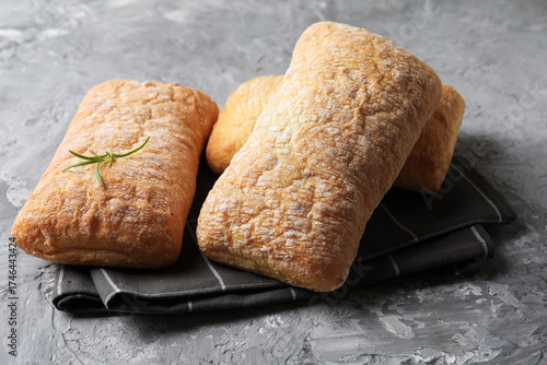 Foto Fresh crispy ciabattas on grey textured table, closeup