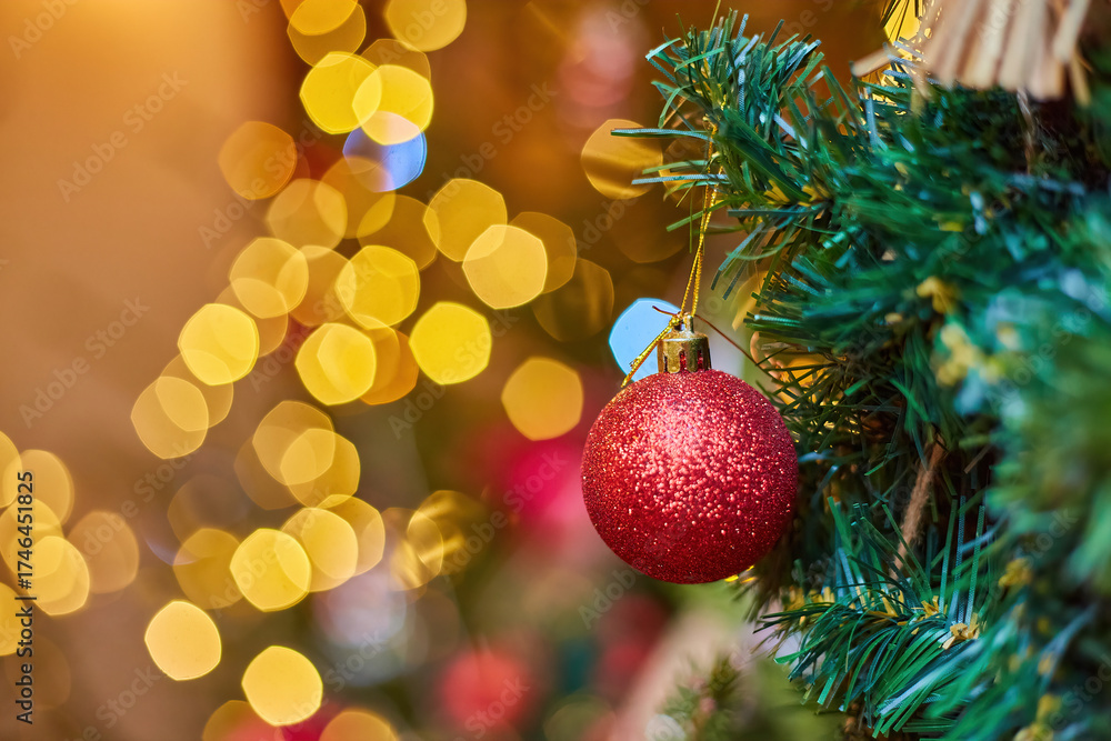 Obraz premium Red glitter Christmas ornament with a magical bokeh lights background.