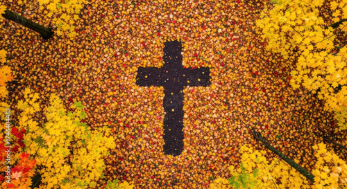 A cross shape in a carpet of autumn leaves. A beautiful and symbolic image of faith, nature, and the changing seasons. Top-down aerial view.