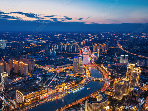 Aerial night view of Tianjin Eye Ferris wheel and city skyline in Tianjin, China