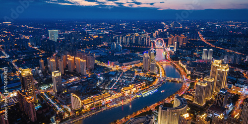 Aerial night view of Tianjin Eye Ferris wheel and city skyline in Tianjin, China