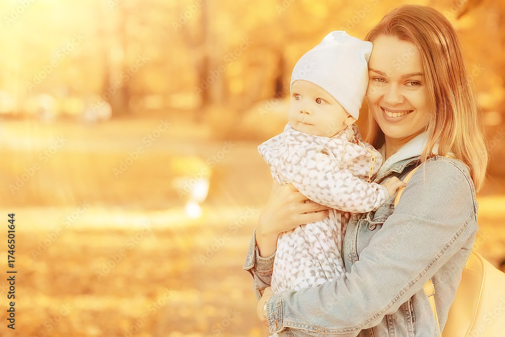Obraz premium mom holding baby in her arms autumn park, outdoor family background fall