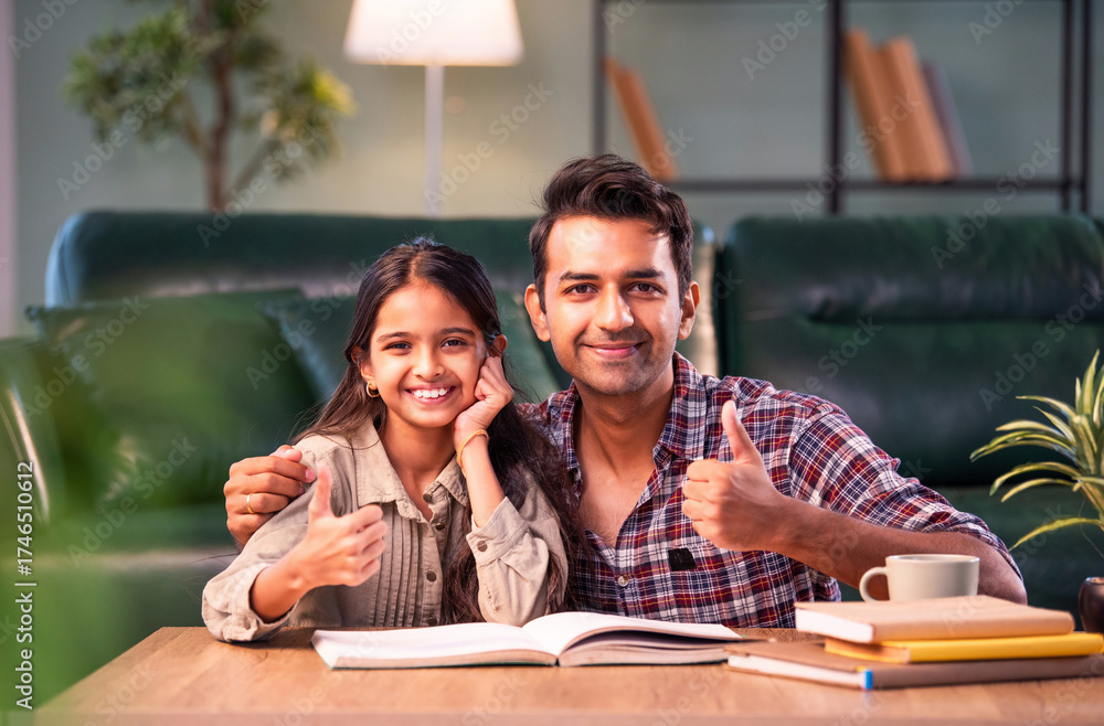 Fototapeta premium Indian Father helping daughter study from textbook, family learning moment at home