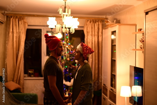 A happy married couple celebrates New Year and Christmas in a cozy apartment