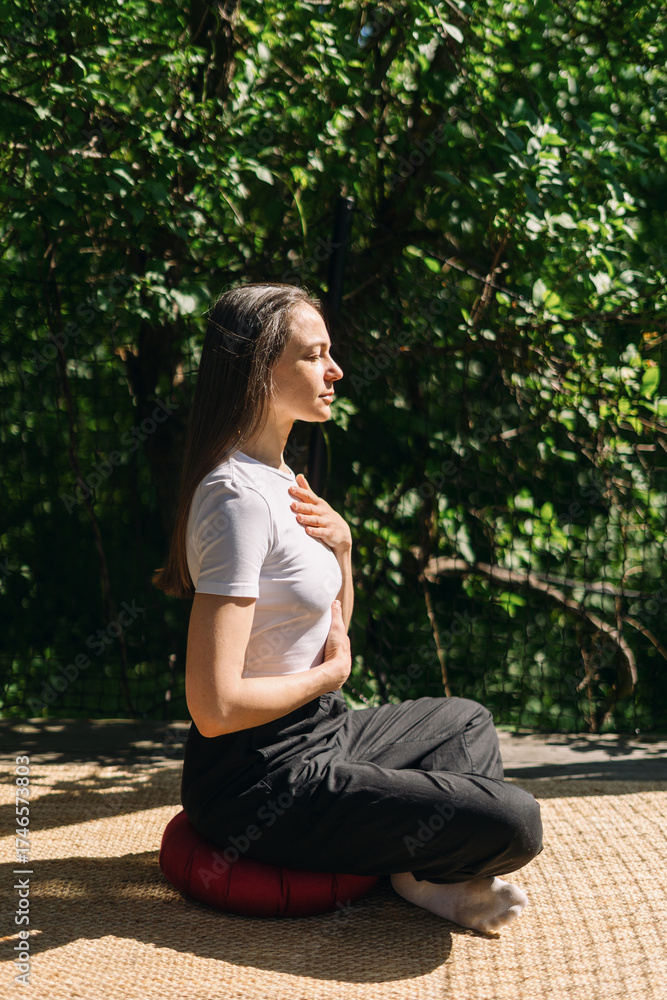 Obraz premium Woman practicing deep breathing and meditation outdoors for mental wellness