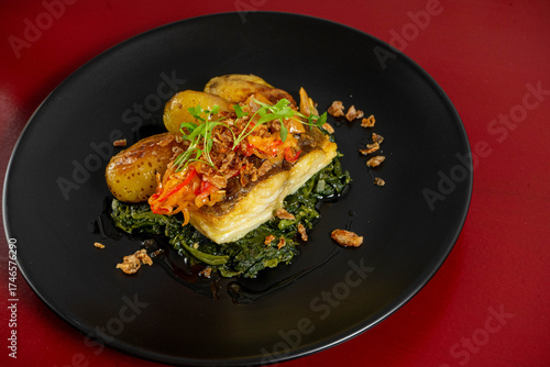 Grilled cod 'à lagareiro' on a bed of Portuguese spinach puree, crafted by a top chef, showcasing traditional flavors and gourmet presentation.