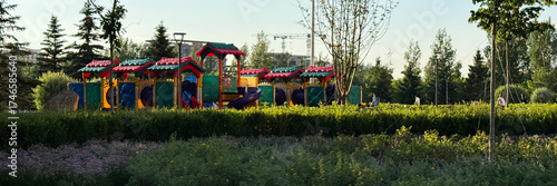 Colorful playground nestled amid lush greenery whispers enchanting tales, evoking Children's Day whimsy and Solstice serenity