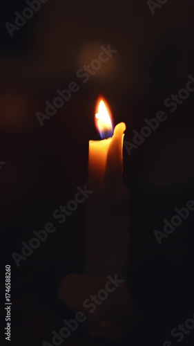 A close-up shot of a glowing candle flame in darkness, symbolizing peace, hope, and meditation. Perfect for spirituality, relaxation, or memorial themes in cinematic or atmospheric visuals.