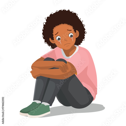 African woman feeling sad, upset, and crying sitting on the floor hugging her legs