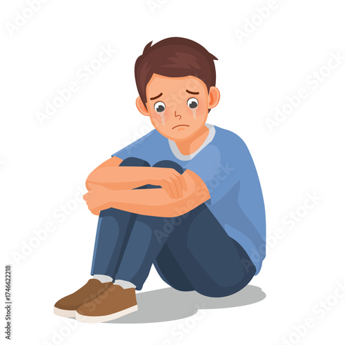 Man feeling sad, upset, and crying sitting on the floor hugging his legs